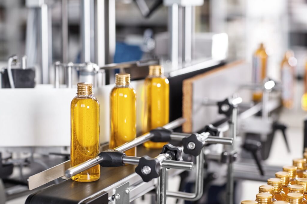 Factory and research concept. Bottles with yellow thick substance standing on manufacturing facility
